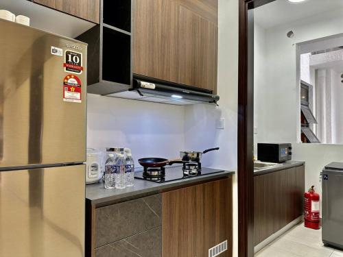 a small kitchen with a stove and a refrigerator at K Avenue Kota Kinabalu in Donggongon