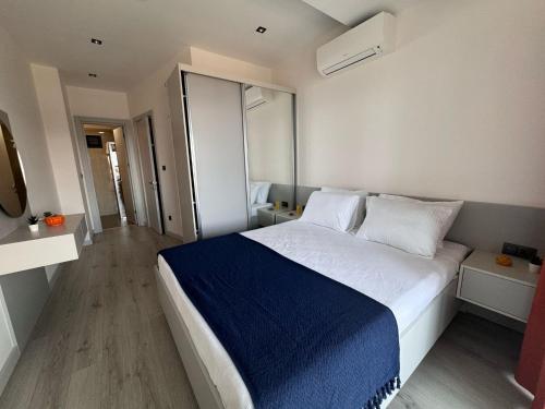 a bedroom with a large bed with a blue blanket at Ulu Panorama Residence in Alanya