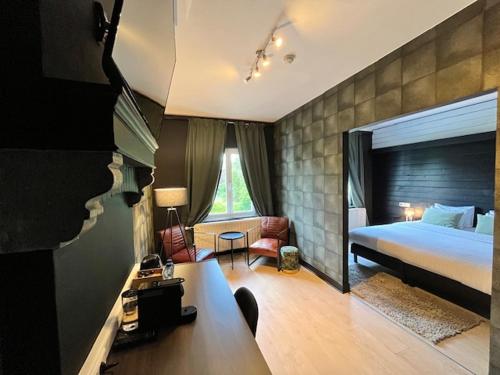 a hotel room with a bed and a desk with a desk at La Villa Blanche Spa in Spa