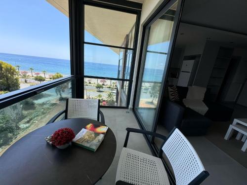 a table and chairs in a room with a view of the ocean at Ulu Panorama Residence in Alanya
