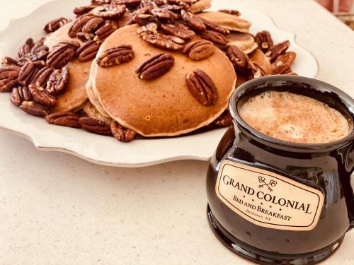 a plate of pancakes and a jar of caramel colonial with pecans at Grand Colonial Bed and Breakfast in Herkimer