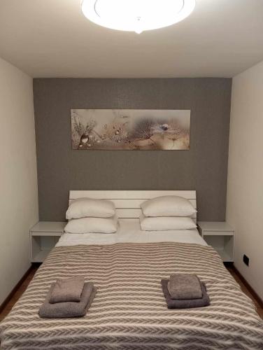 a bedroom with a large bed with two towels on it at City apartment in Pärnu