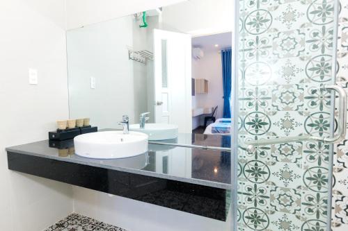 a bathroom with a sink and a mirror at Lee House Villa Tam Thanh in Tam Ky