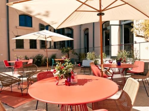 an outdoor patio with tables and chairs and umbrellas at Ostello Bello Palermo in Palermo
