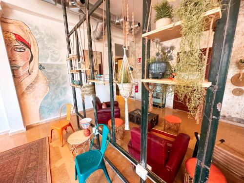 a living room with chairs and a painting on the wall at Ostello Bello Palermo in Palermo