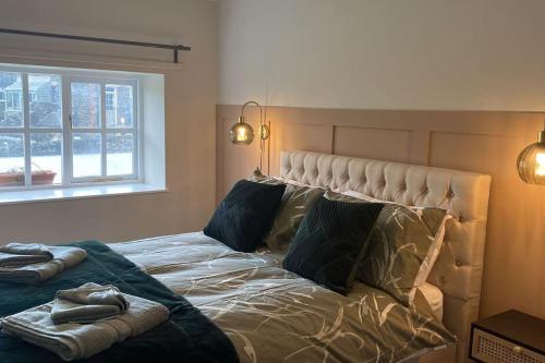 ein Schlafzimmer mit einem Bett mit zwei Kissen und einem Fenster in der Unterkunft Ash Cottage in Windermere