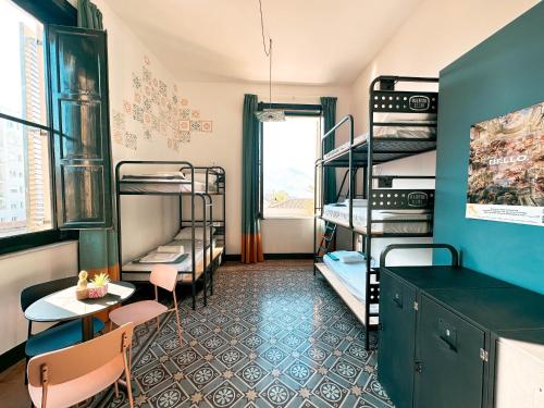 a room with bunk beds and a table and chairs at Ostello Bello Palermo in Palermo