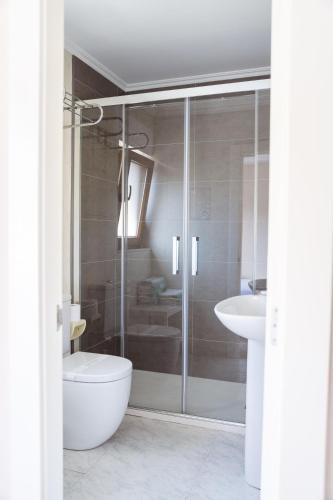 a bathroom with a shower and a toilet and a sink at Pensión San Jorge in Nueva de Llanes