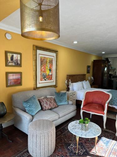a living room with a couch and a bed at Constantia View Apartments- Luxury Self Catering in Cape Town