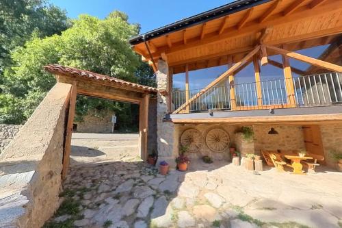a house with a balcony and a patio at Cal Cumell, Allotjament turístic in Aransá