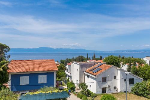 a group of houses on a hill next to the water at Apartmani Tena in Njivice