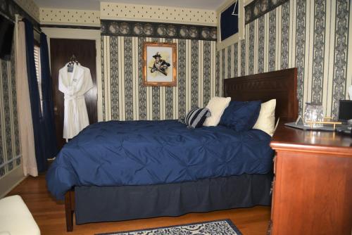 a bedroom with a bed and a dress hanging on a wall at Grand Colonial Bed and Breakfast in Herkimer