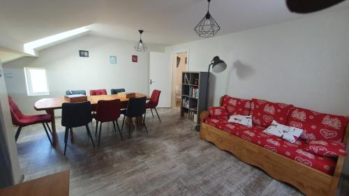 un salon avec un canapé rouge et une table dans l'établissement GITE La SCHLITTE, à La Bresse
