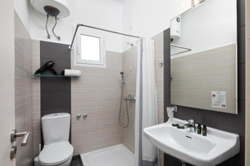 a bathroom with a toilet and a sink and a shower at Bella Vista Beach Hotel in Benitses