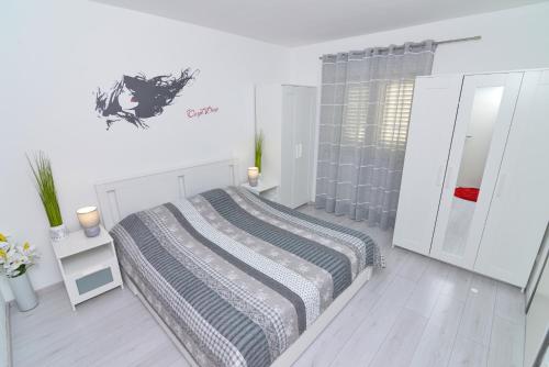 a white bedroom with a bed and a mirror at Memory Box Apartman - Šibenik in Šibenik