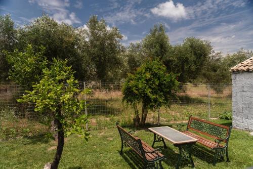 a picnic table and two benches in a yard at Dimitras Home in Lefkímmi