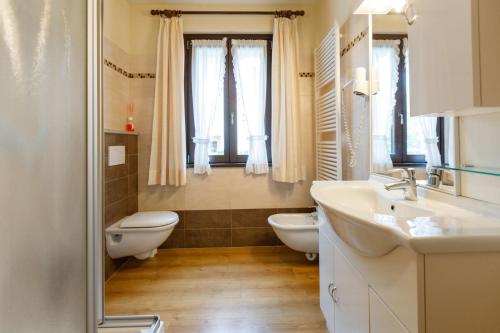 a bathroom with two sinks and a toilet and a window at Chalet Silvi Residence in Bormio