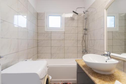 a bathroom with a sink and a tub and a toilet at Dimitras Home in Lefkímmi