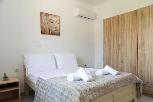 a bedroom with a bed with towels on it at Dimitras Home in Lefkímmi