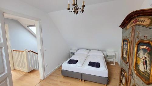 a bedroom with a bed and a chandelier at Schieszl Villa in Zamárdi