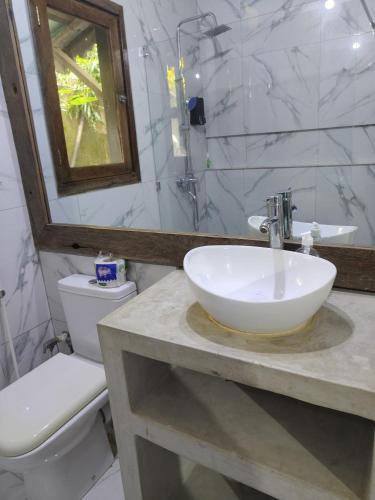 a bathroom with a sink and a toilet at POLE POLE House in Nungwi