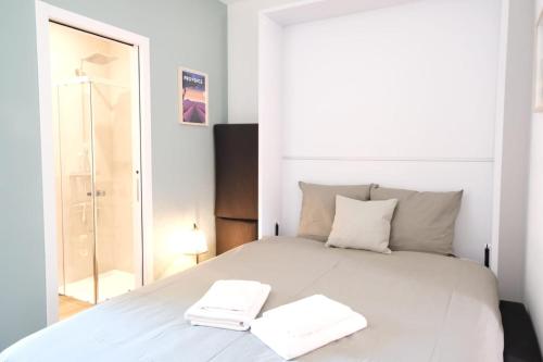 une chambre avec un lit blanc avec deux serviettes dessus dans l'établissement Studio rénové avec belle terrasse, à Aix-en-Provence