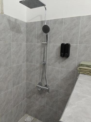 a shower with a shower head in a bathroom at POLE POLE House in Nungwi