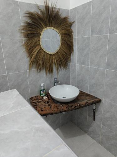 a bathroom with a sink and a mirror at POLE POLE House in Nungwi