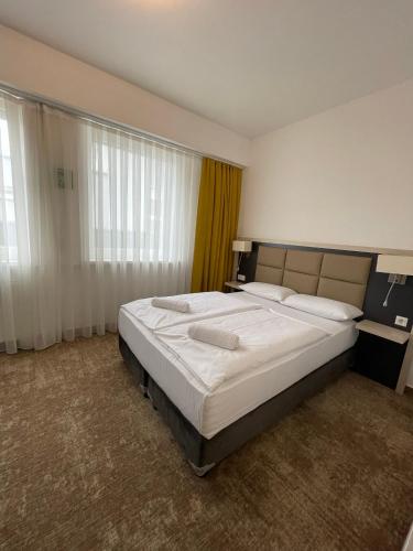 1 dormitorio con 1 cama grande con sábanas blancas en THE PLACE HOTEL - Frankfurt City Messe, en Frankfurt