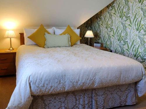 a bedroom with a bed with yellow pillows and avertisement at Chough's Nest Hotel in Lynton