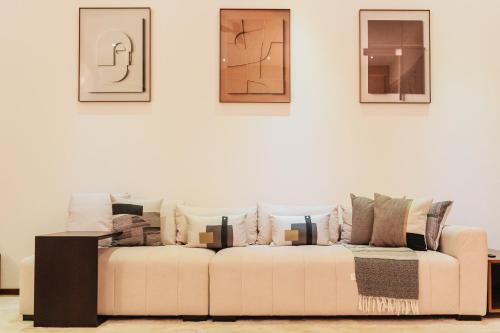 un sofá blanco en una sala de estar con cuadros en la pared en Waves and Whispers -by Hestia Living, en Mombasa