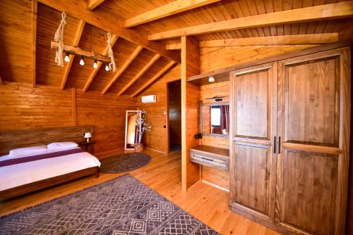 a bedroom with a bed and a wooden ceiling at Zūhre Cafe Bungalow in Demre