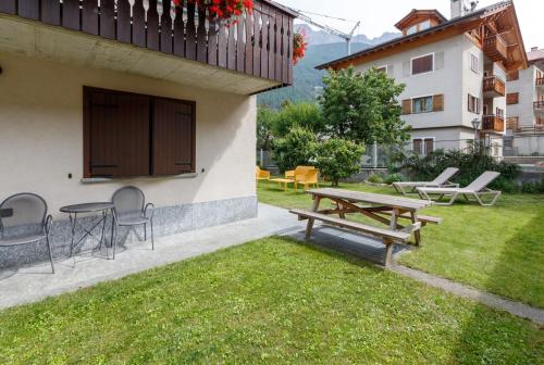 a patio with a picnic table and chairs in a yard at Chalet Silvi Residence in Bormio