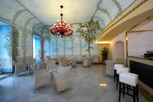 a restaurant with a chandelier and tables and chairs at Grand Hotel Piazza Borsa in Palermo