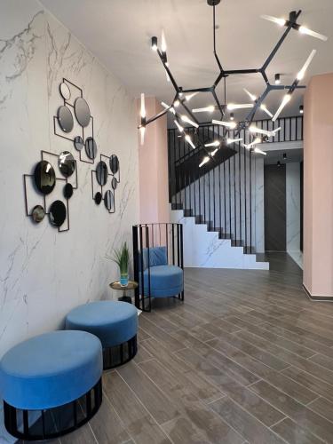a lobby with two blue stools and a staircase at EVRA APARTMENTS Royal 2 in Timişoara