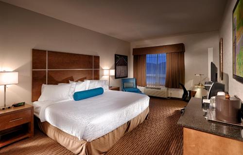 una camera d'albergo con un grande letto e una grande finestra di Canalta Kindersley a Kindersley