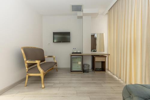 a room with a chair and a television on a wall at Bursa Grand Family HOTEL in Bursa