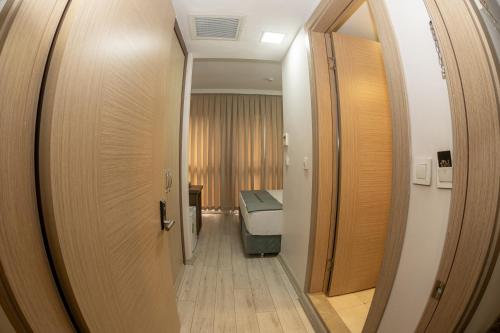 a hallway leading to a room with a bed and a mirror at Bursa Grand Family HOTEL in Bursa