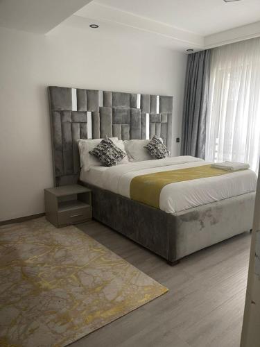 a bedroom with a large bed with a large headboard at Silverstone Apartments Nairobi, Kilimani in Nairobi