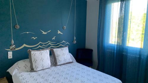 - une chambre avec un lit avec des oiseaux sur le mur dans l'établissement maison familiale de vacances, à Mazan