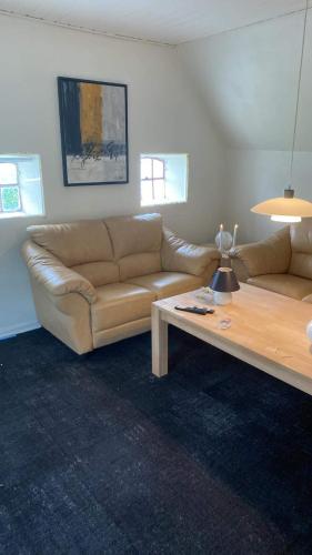 a living room with a couch and a coffee table at Nedlagt Landbrug med 3 lejligheder in Vejle