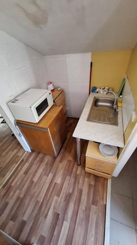 a small kitchen with a sink and a microwave at Apartments Londa in Jūrmala