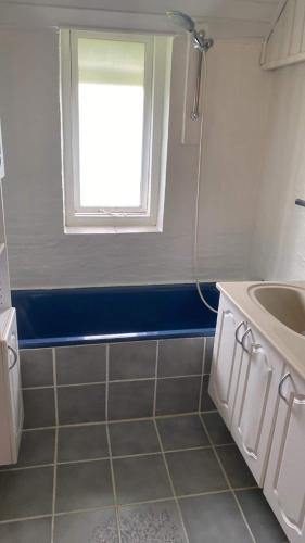 a bathroom with a sink and a window at Nedlagt Landbrug med 3 lejligheder in Vejle