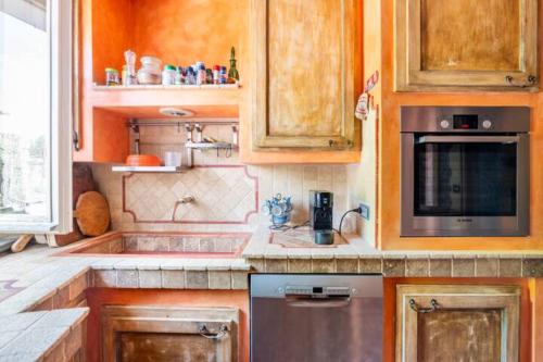 a kitchen with wooden cabinets and a stainless steel appliance at Villa Dacia in Guiglia