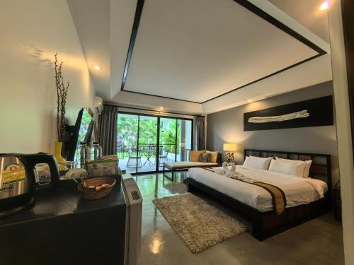 a bedroom with a large bed and a desk and a room at 清迈三诺河畔精品度假酒店 in Chiang Mai