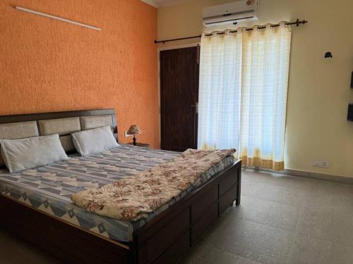 a bedroom with a large bed in a room at Comfy 3BHK house with Cinema like Home Theatre ! in Sohāna