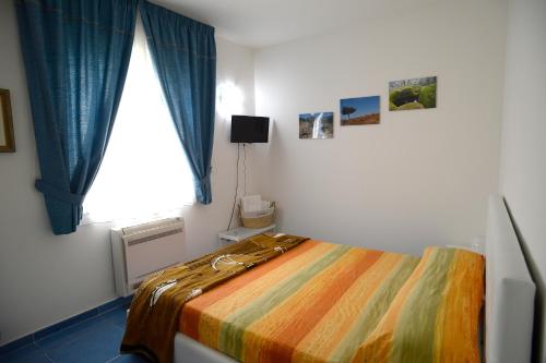 a bedroom with a bed with a colorful blanket at Il Sestante B&B in Condofuri