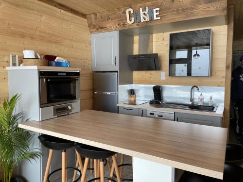 une cuisine avec un comptoir en bois dans une pièce dans l'établissement Duplex Les Plautus 2 - Orcières-Merlette - Appt vue montagne, à Orcières
