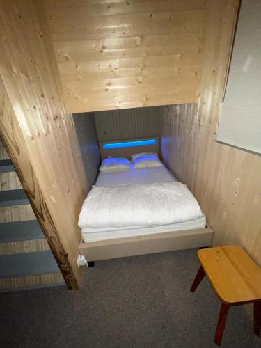 Cette chambre en bois comprend un petit lit et une table. dans l'établissement Duplex Les Plautus 2 - Orcières-Merlette - Appt vue montagne, à Orcières