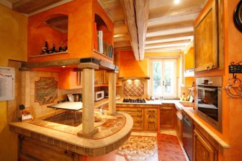 a large kitchen with wooden cabinets and a stone counter top at Villa Dacia in Guiglia